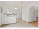 White kitchen with island, tiled floor and access to backyard at 5547 S Lowell Blvd, Littleton, CO 80123