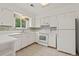 White kitchen with tiled floors and mosaic backsplash at 5547 S Lowell Blvd, Littleton, CO 80123