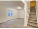 Carpeted basement area with staircase, egress window, and neutral paint at 11213 Vilas St, Parker, CO 80134