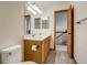 Well-lit bathroom features double sink vanity and wood look floors with open doorway at 11213 Vilas St, Parker, CO 80134