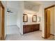 Bathroom features double sinks, wooden cabinets, tile floor and open entrance to bedroom at 11213 Vilas St, Parker, CO 80134