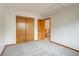 Bedroom with double door closet, bright neutral paint, and wood door entrance at 11213 Vilas St, Parker, CO 80134