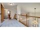 Upstairs hallway overlooking living area with carpeted floors and wood banister at 11213 Vilas St, Parker, CO 80134