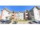 Condominium complex shows garages, brick facade, and well-manicured lawn under a clear blue sky at 14333 E 1St Dr # 108, Aurora, CO 80011