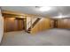 Spacious basement with carpeted floor, wood paneled walls, and access to the upper floor at 180 Dover St, Lakewood, CO 80226