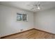 Bedroom featuring hardwood floors, neutral paint, a ceiling fan and window with outside view at 180 Dover St, Lakewood, CO 80226