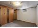 A basement bedroom with carpet, wood paneling, and a small window at 180 Dover St, Lakewood, CO 80226