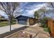 Home exterior with a long driveway, basketball hoop, and neat garden bed, highlighted by a wooden privacy fence at 180 Dover St, Lakewood, CO 80226