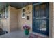 Close-up of the front door with secure entry, brick facade and colorful flower pot with flowers at 180 Dover St, Lakewood, CO 80226