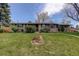 Attractive one-story home boasting a lush green lawn, brick exterior, mature landscaping, and inviting curb appeal at 180 Dover St, Lakewood, CO 80226