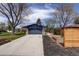 View of the detached garage, driveway, garden bed and backyard of this property at 180 Dover St, Lakewood, CO 80226