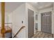Foyer view of wood staircase, the entry door and view into the kitchen with tiled flooring at 180 Dover St, Lakewood, CO 80226