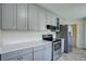 Modern kitchen featuring gray cabinets, stainless steel appliances, white countertops, and ample storage space at 180 Dover St, Lakewood, CO 80226