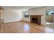 Bright living room features a brick fireplace, hardwood floors, and access to outdoor patio at 180 Dover St, Lakewood, CO 80226