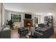 Cozy living room featuring a brick fireplace, hardwood floors, and comfortable seating at 180 Dover St, Lakewood, CO 80226