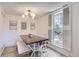 Bright dining room with modern lighting, wooden table, bench, and window with shutters at 10001 E Evans Ave # 74C, Aurora, CO 80247