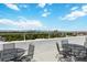Rooftop balcony overlooking trees, buildings and mountains, furnished with black metal outdoor furniture at 1155 N Ash St # 1408, Denver, CO 80220