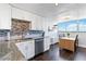 Updated kitchen with white cabinets, stainless steel appliances, granite countertops, and a view of the city at 1155 N Ash St # 1408, Denver, CO 80220