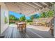 Covered patio featuring a seating area with a chandelier and hot tub in the distance, ready for entertaining at 8000 S Williams Way, Centennial, CO 80122