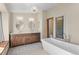 Elegant bathroom with dual vanities, a soaking tub, and a separate glass shower featuring a chandelier at 8000 S Williams Way, Centennial, CO 80122
