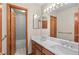Well-lit bathroom featuring double sinks, a large mirror, and a separate toilet and shower area at 8000 S Williams Way, Centennial, CO 80122