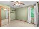 Green bedroom with a ceiling fan, window, curtains, shelf, and mirrored closet creating a calming space at 8000 S Williams Way, Centennial, CO 80122