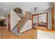 Welcoming foyer featuring hardwood floors, a staircase with carpet, and a view into the living room at 8000 S Williams Way, Centennial, CO 80122
