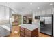 Open kitchen with an island, stainless steel refrigerator, granite countertops, and hardwood floors at 8000 S Williams Way, Centennial, CO 80122