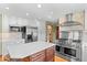 Modern kitchen with stainless steel appliances, a large island, white cabinets, and a brick backsplash at 8000 S Williams Way, Centennial, CO 80122