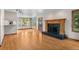 Open living space with hardwood floors, a fireplace, built-in cabinets, and access to a sunroom at 8000 S Williams Way, Centennial, CO 80122