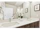 Bathroom featuring a double sink vanity, large mirror, white countertop, and wood-tone cabinetry at 20 Wilcox St # 309, Castle Rock, CO 80104