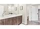 Bathroom featuring a double sink vanity, stylish mirror, and a glimpse of a separate toilet room at 20 Wilcox St # 309, Castle Rock, CO 80104