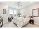 A cozy bedroom featuring a black chair, an area rug, a bed with decorative pillows, and a ceiling fan at 20 Wilcox St # 309, Castle Rock, CO 80104