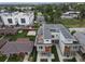 An aerial view showcases modern townhouses in a green neighborhood, surrounded by mature trees and mountain views at 1355 Zenobia St, Denver, CO 80204