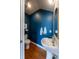 Chic powder room featuring blue walls, modern fixtures, and hardwood flooring at 1355 Zenobia St, Denver, CO 80204