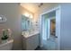 Bright bathroom features a modern vanity, stylish mirror, and a view into the hallway at 1355 Zenobia St, Denver, CO 80204