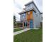 Modern home boasts a blue door, brick accents, stylish wood, and a lush lawn at 1355 Zenobia St, Denver, CO 80204