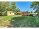 Spacious backyard featuring green lawn, mature trees, storage shed and brick home with solar panels at 3354 W Arlington Ave, Littleton, CO 80123