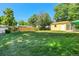 Large, grassy backyard with a wood fence, mature trees, and a detached garage at 3354 W Arlington Ave, Littleton, CO 80123