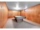 Spacious basement featuring a pool table, wood paneling, and carpet flooring at 3354 W Arlington Ave, Littleton, CO 80123