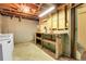 Unfinished basement area with a workbench, shelving, and view of the unfinished ceiling and exposed utilities at 3354 W Arlington Ave, Littleton, CO 80123