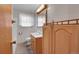 Modest bathroom has wood cabinets, vanity, and updated light fixture at 3354 W Arlington Ave, Littleton, CO 80123