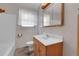Modest bathroom with tiled walls and white vanity features an updated mirror at 3354 W Arlington Ave, Littleton, CO 80123