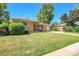 Charming single-story brick home features a well-manicured lawn and long driveway at 3354 W Arlington Ave, Littleton, CO 80123