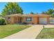 Attractive single-story brick home boasts a well-kept lawn, long driveway, and an attached garage at 3354 W Arlington Ave, Littleton, CO 80123