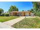 Charming single-story brick home features a well-manicured lawn, long driveway, and attached garage at 3354 W Arlington Ave, Littleton, CO 80123