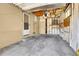 Unfinished garage with exposed insulation, a side door, a window, and a concrete floor at 3354 W Arlington Ave, Littleton, CO 80123