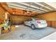 Garage space with concrete floor, exposed utilities, boxes of storage, and a silver car at 3354 W Arlington Ave, Littleton, CO 80123