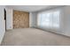 Spacious living room with a brick accent wall, plush carpeting, and lots of natural light at 3354 W Arlington Ave, Littleton, CO 80123