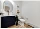 Bathroom featuring a dark vanity with gold hardware, a round mirror, and wood-look flooring at 2857 Linden Dr, Boulder, CO 80304